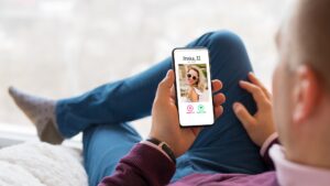 Man sitting down browsing a dating app on his phone